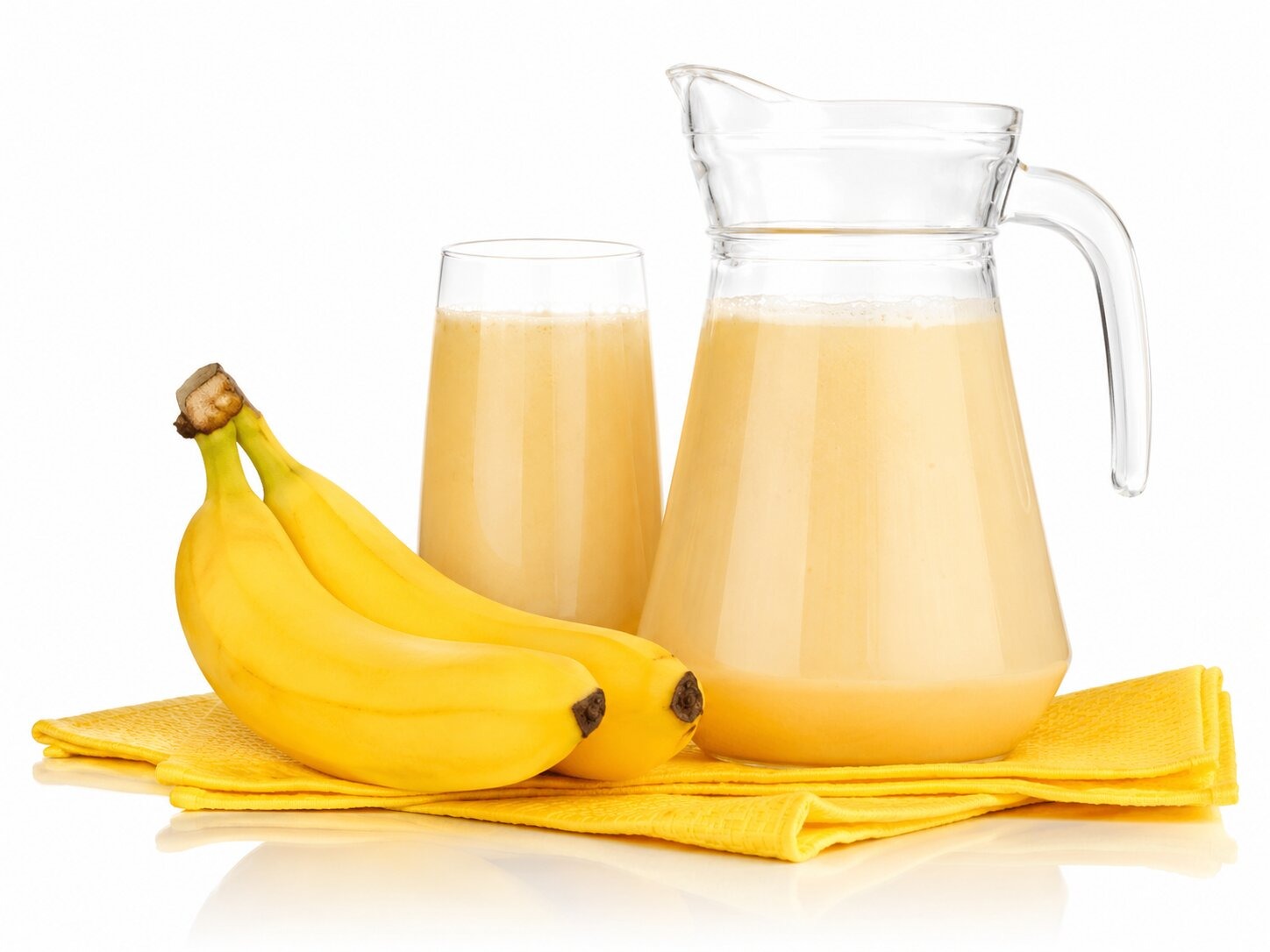 2 Bananas next to a glass and jug of Umutobe